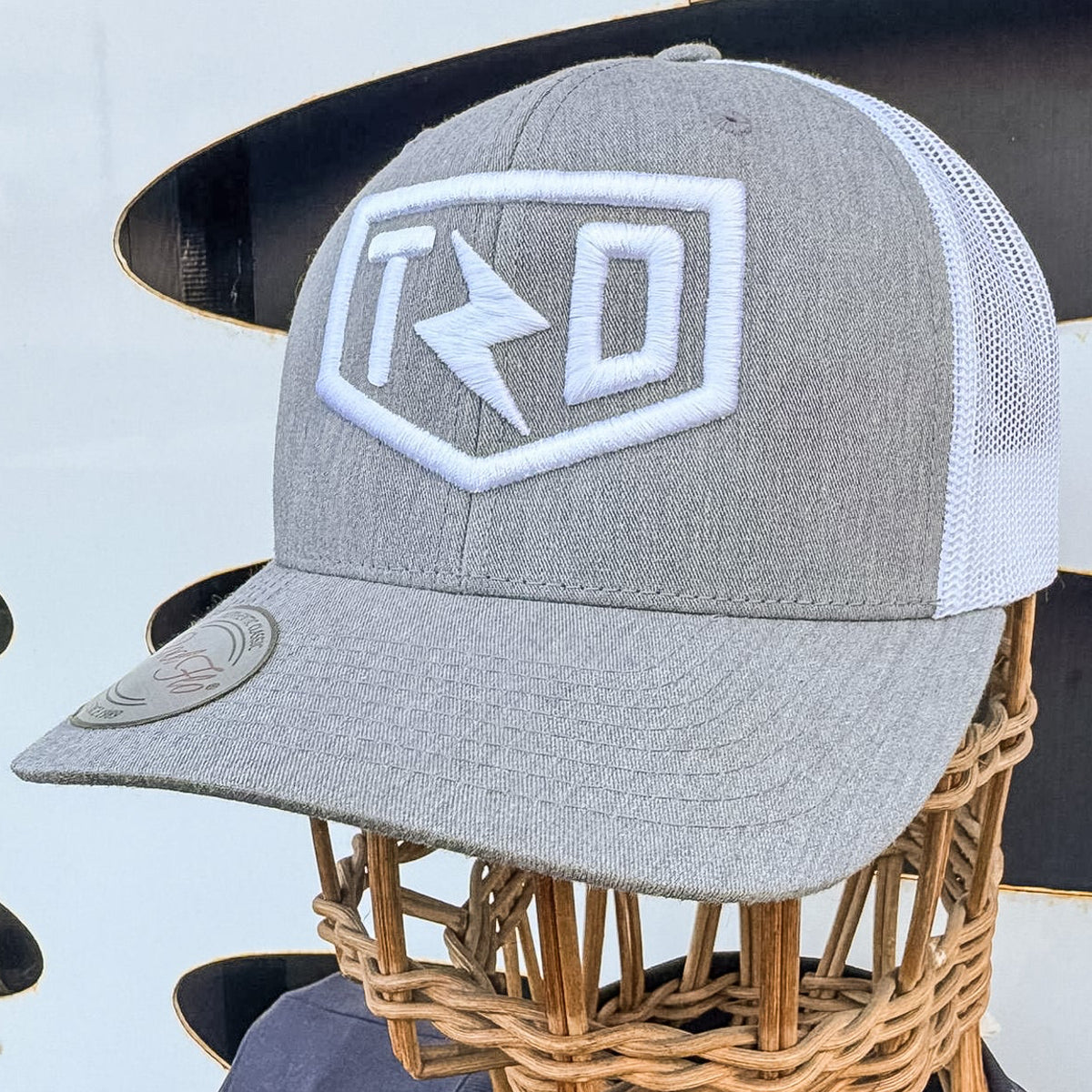 Gray cap with a logo on a mannequin head against a white background